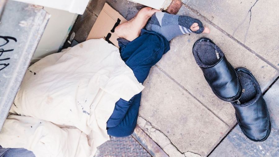 Los Angeles homeless man sleeping rough on pavement