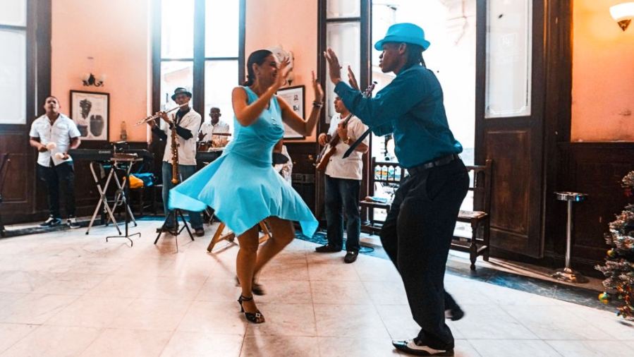Couple dancing in vibrant setting.