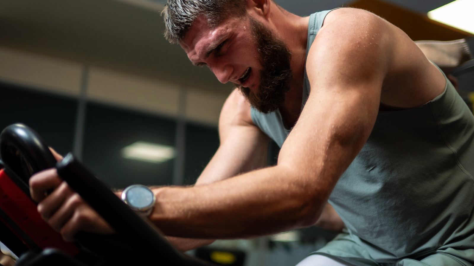 Man engaged in focused indoor cycling session showcasing fitness and determination.