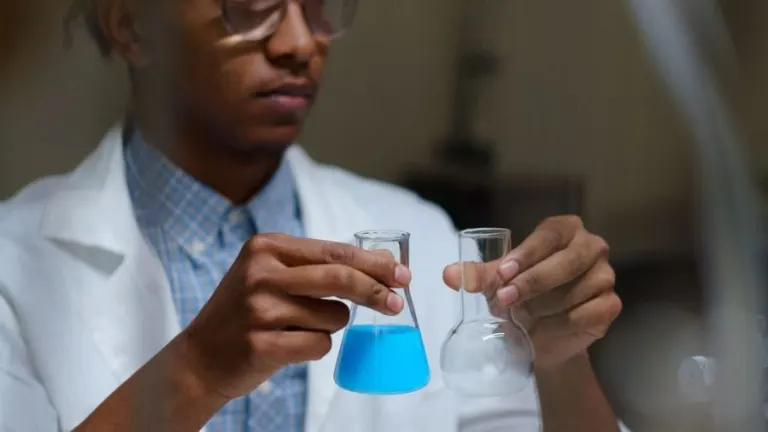 Focused young scientist mixing chemicals during an experiment in a laboratory.