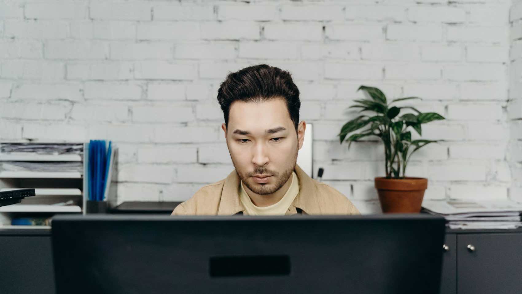 An office worker concentrating on tasks at his modern desk in a contemporary setting.