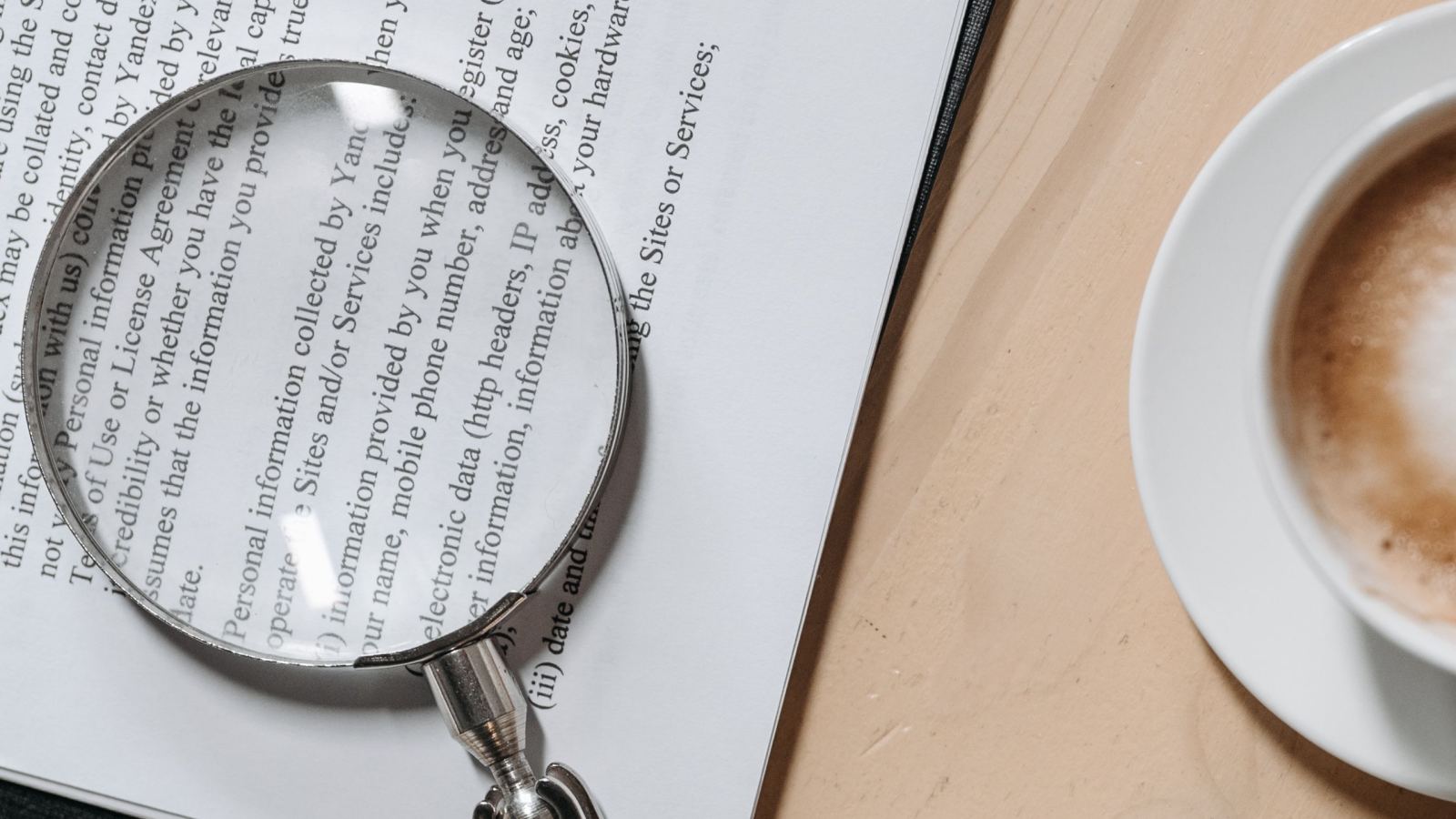 Top view of documents with a magnifying glass and pen, ideal for business or legal themes.