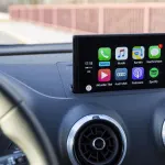 Photo of a luxury car's interior showcasing the digital navigation and audio display system.