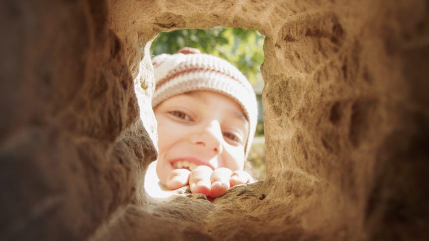 Child looking through a tunnel