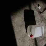 A solitary plastic canister rests on the floor, bathed in dramatic shadows.